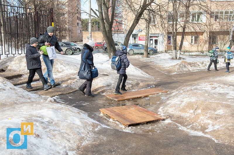 Возле прохода на территорию лицея №2, В Одинцово снежные отходы разбрасывают по газонам и тротуарам